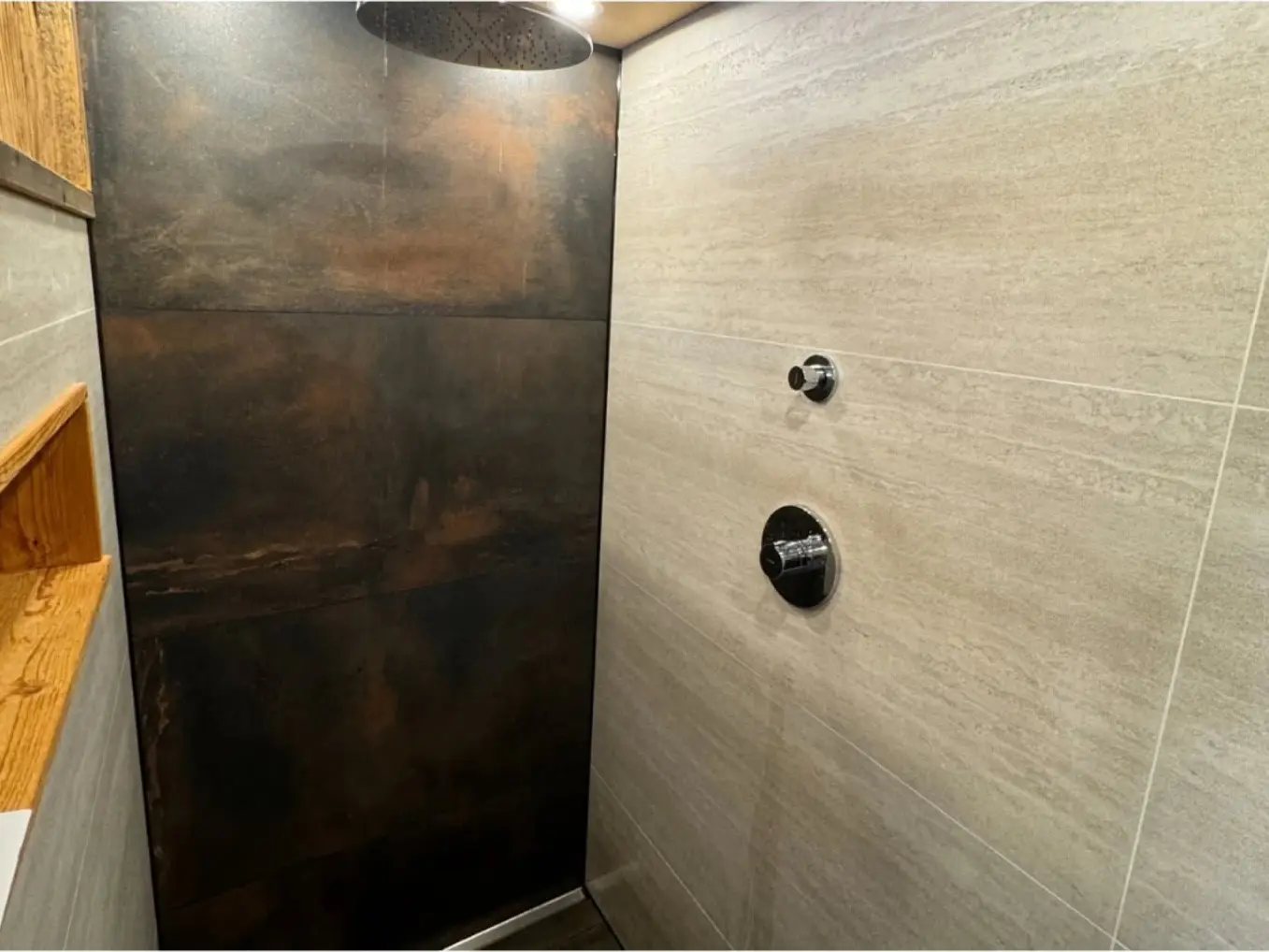Echte Referenz: Walk-in-Dusche mit Regenbrause, Rostoptik-Wand und Travertin-Fliesen — Badsanierung von SANITECs, 2025